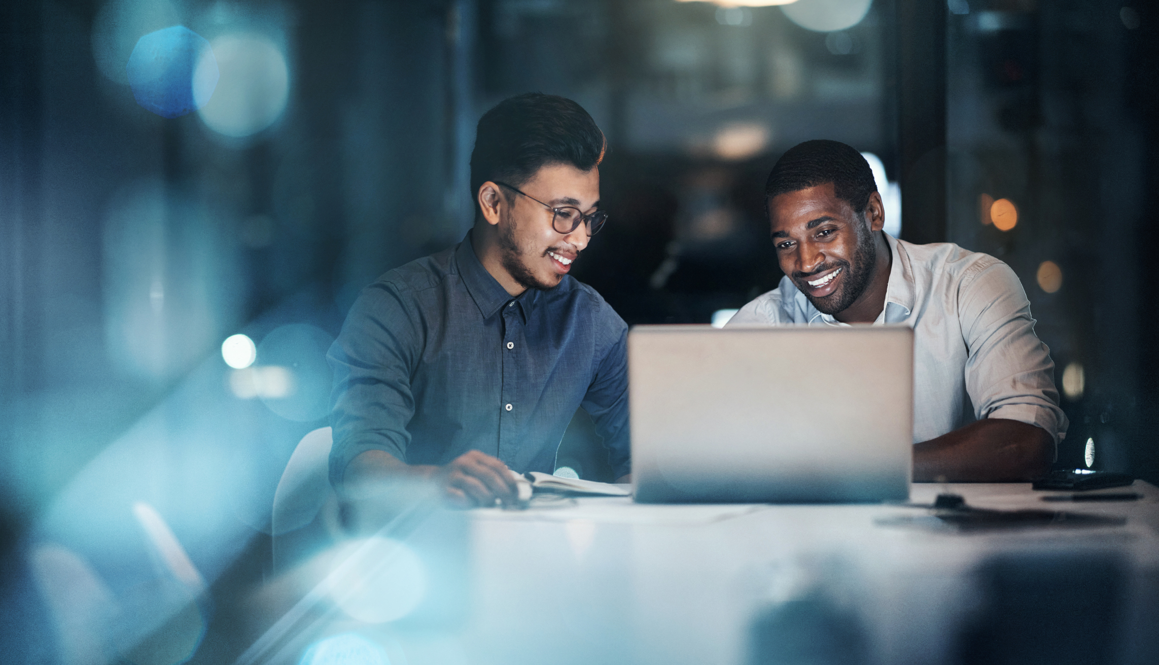 Two employees working together on a laptop