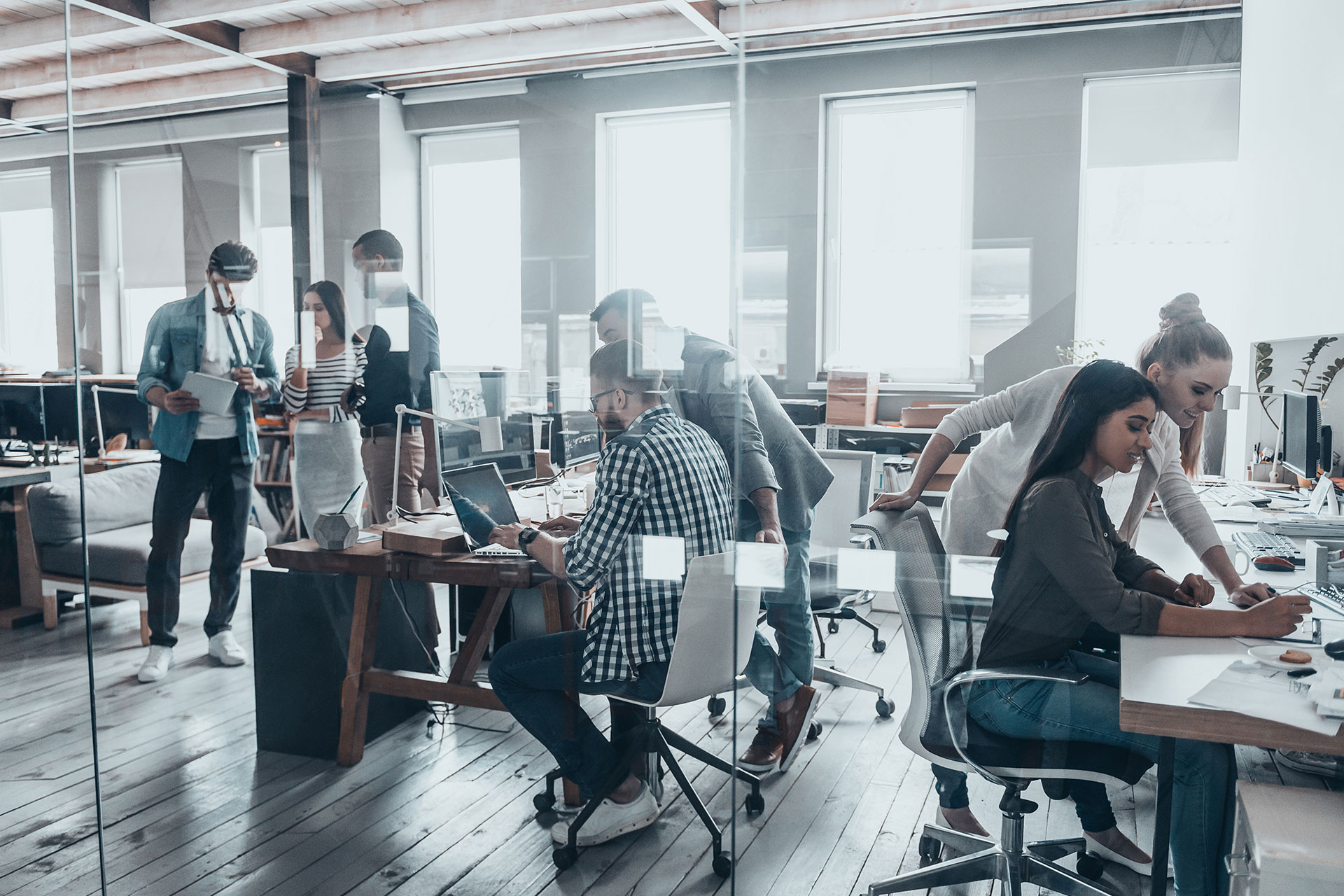 people working in an office behind glass doors